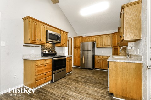 a kitchen with wooden cabinets and stainless steel appliances