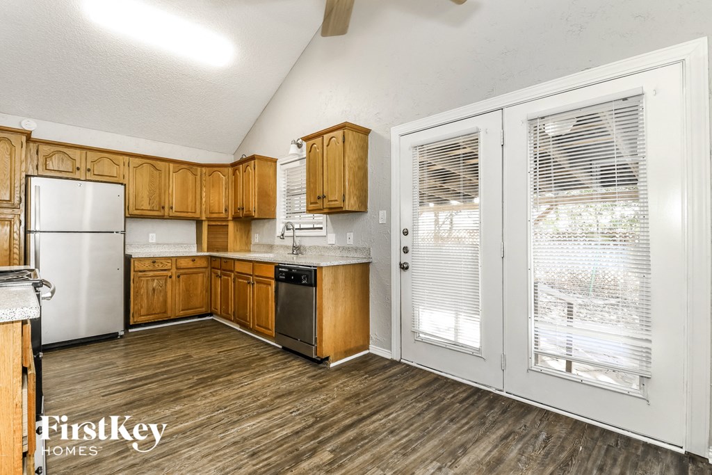 a kitchen with wood floors and wooden cabinets and a white refrigerator