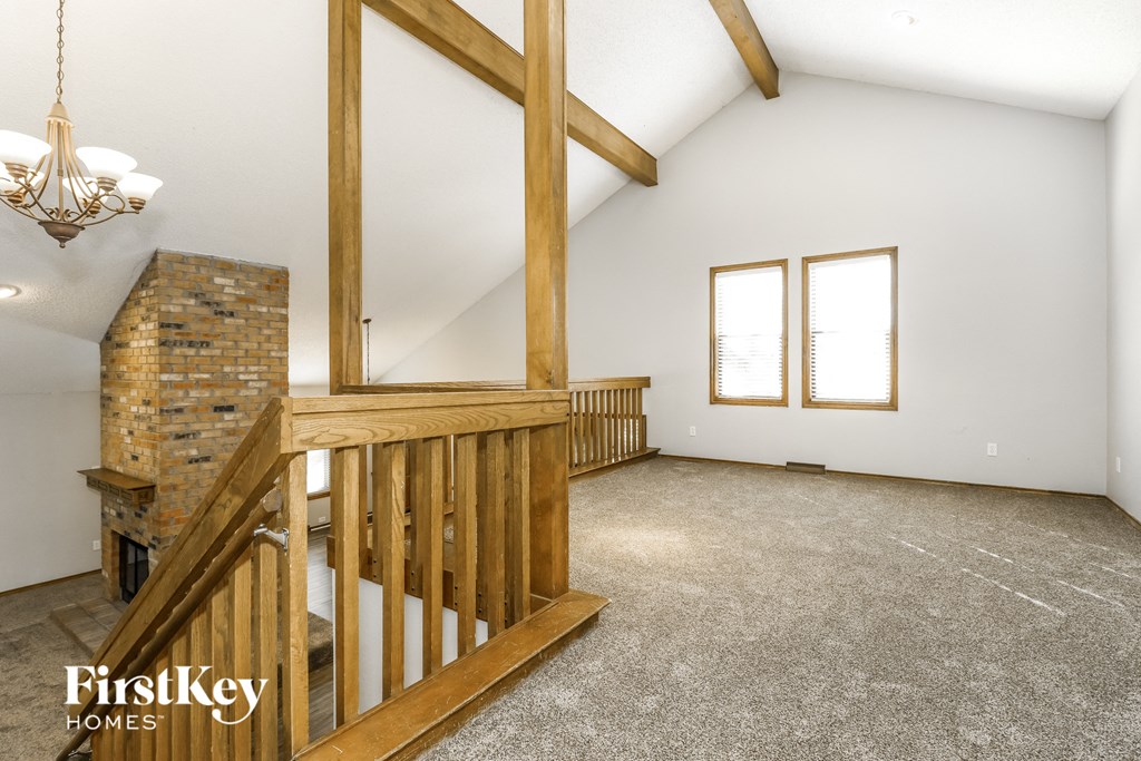 an attic room with a staircase and a brick fireplace