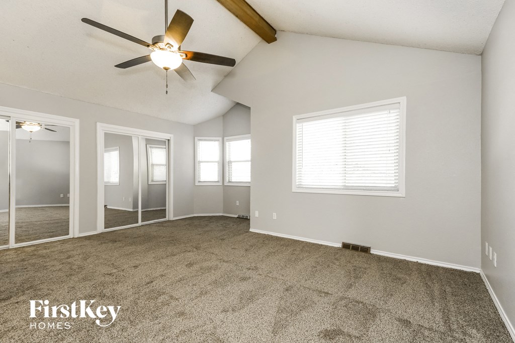 the living room of an empty house with a ceiling fan