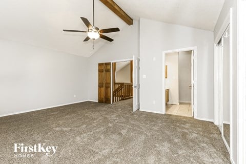 a living room with carpet and a ceiling fan