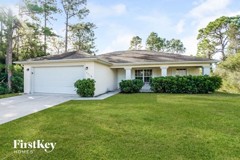 a white house with a lawn and a white garage door