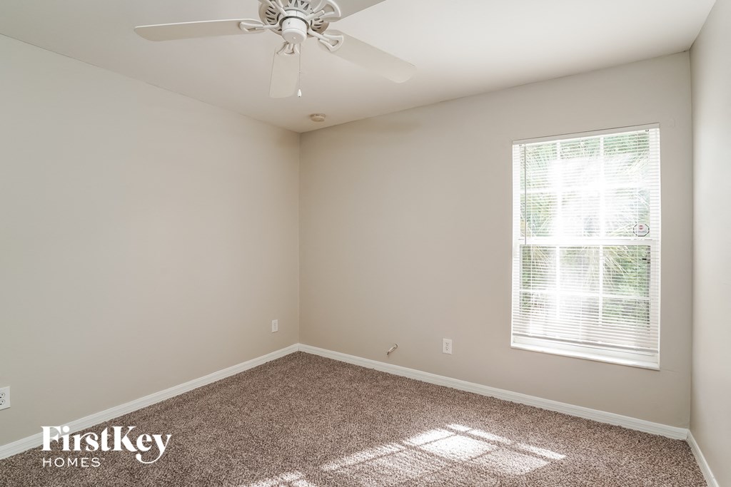 a bedroom with a ceiling fan and a window
