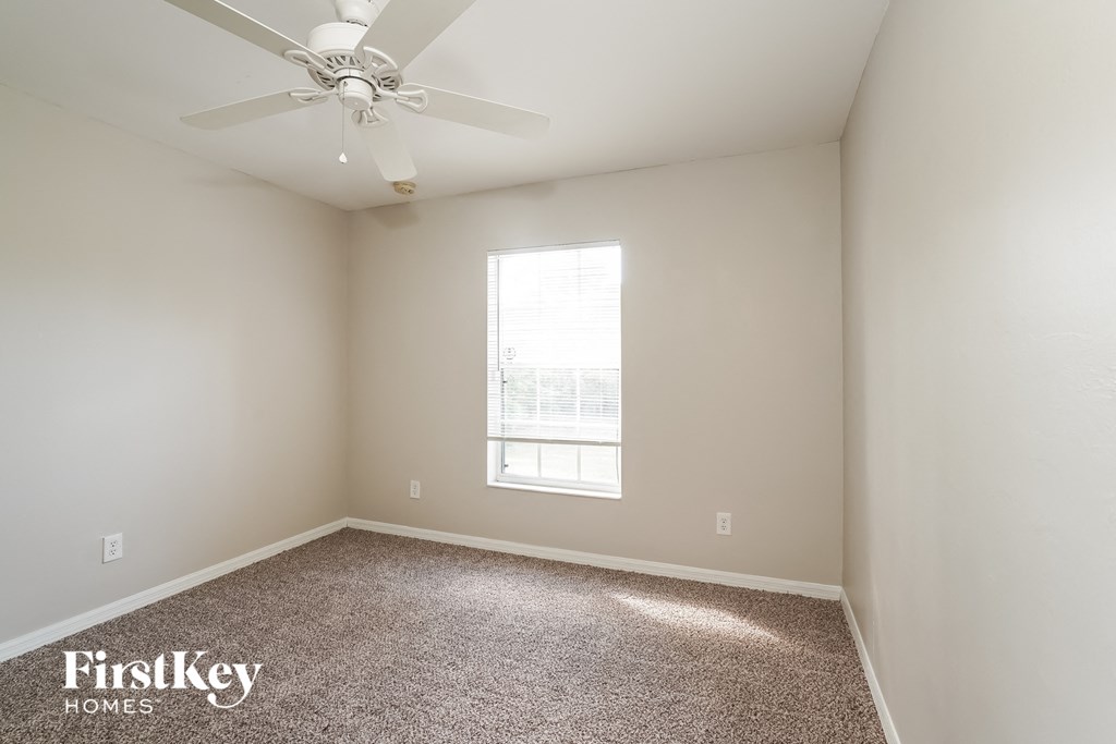 a bedroom with a ceiling fan and a window