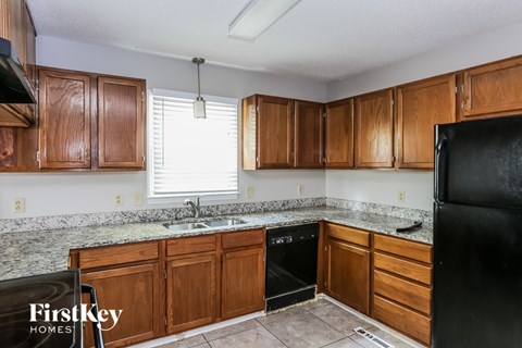 a kitchen with wooden cabinets and black appliances and granite counter tops