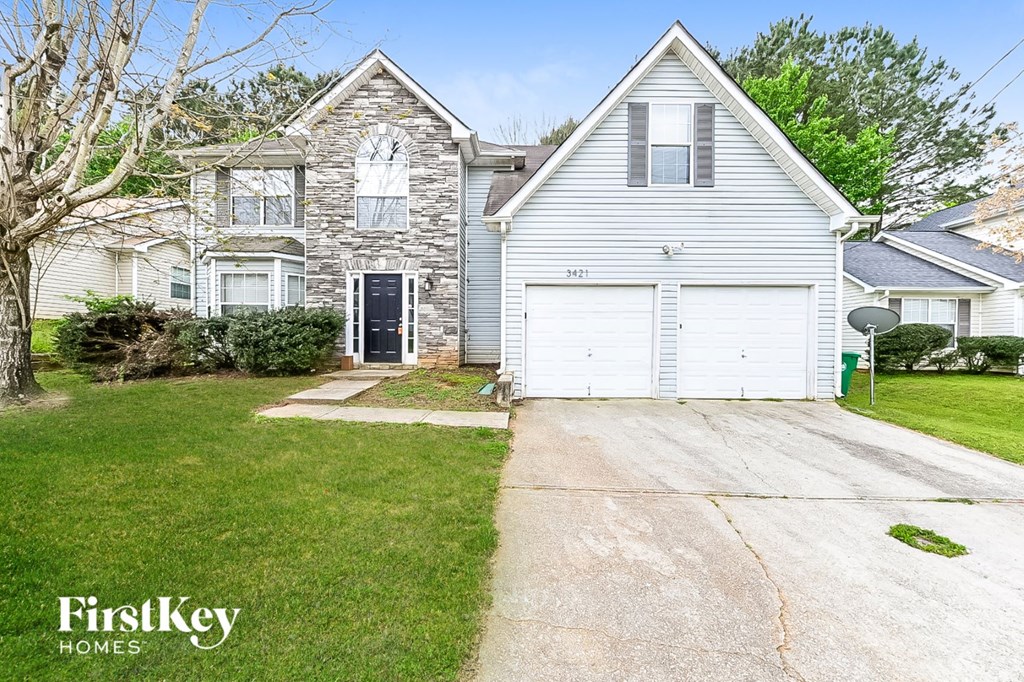 a white house with a white garage door in front of a green yard