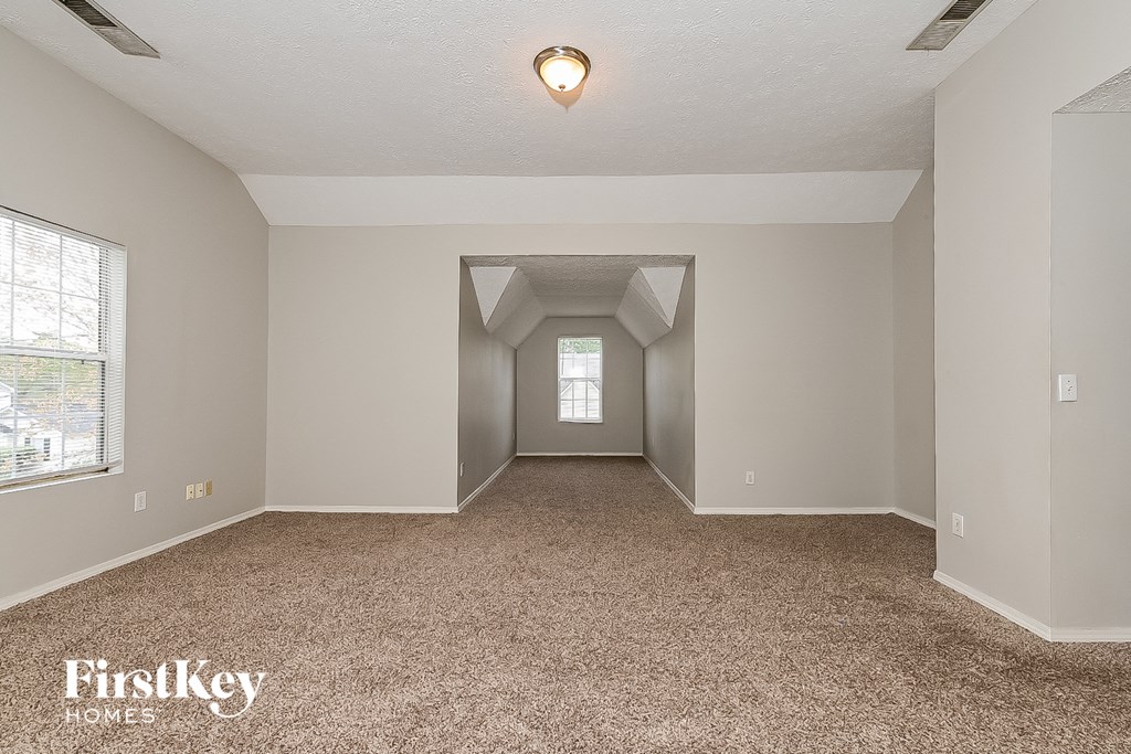 the living room of an empty house with a carpeted floor