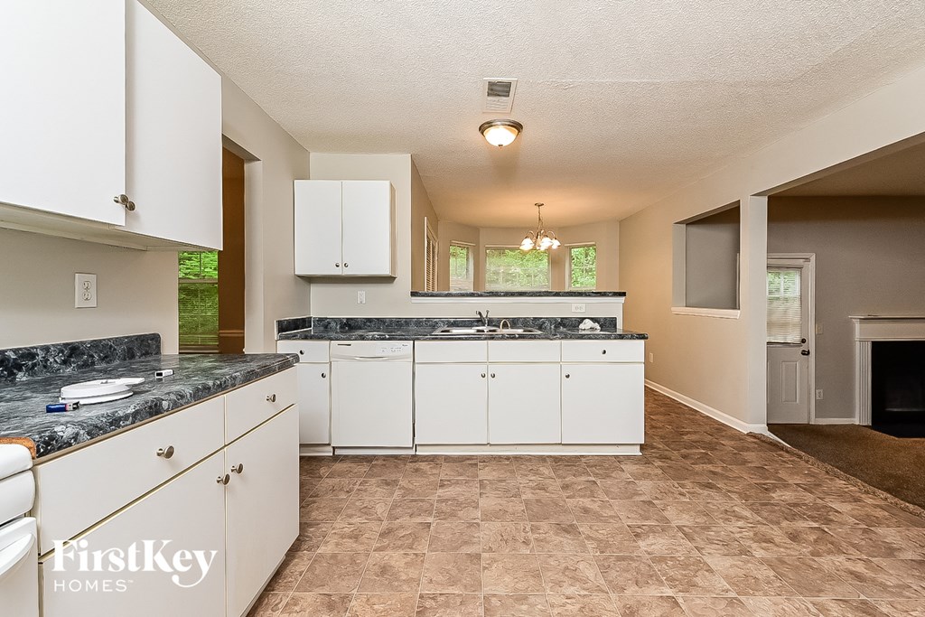 a kitchen with white cabinets and granite counter tops