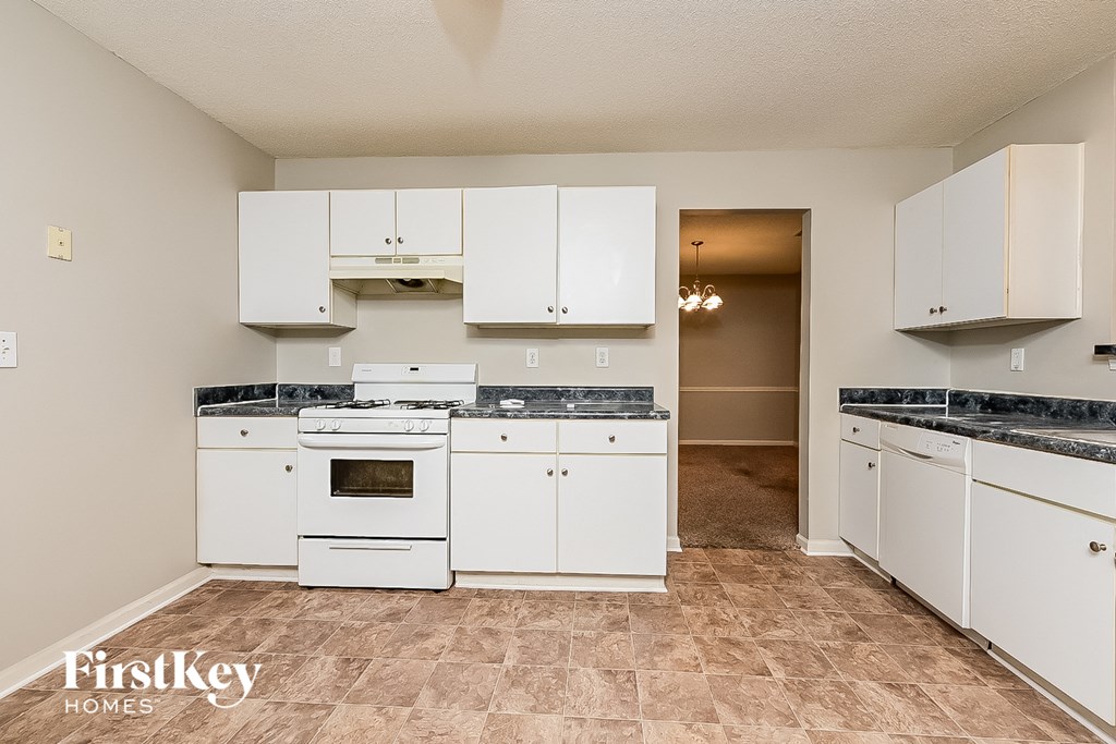 the kitchen is clean and ready to use with white cabinets and appliances