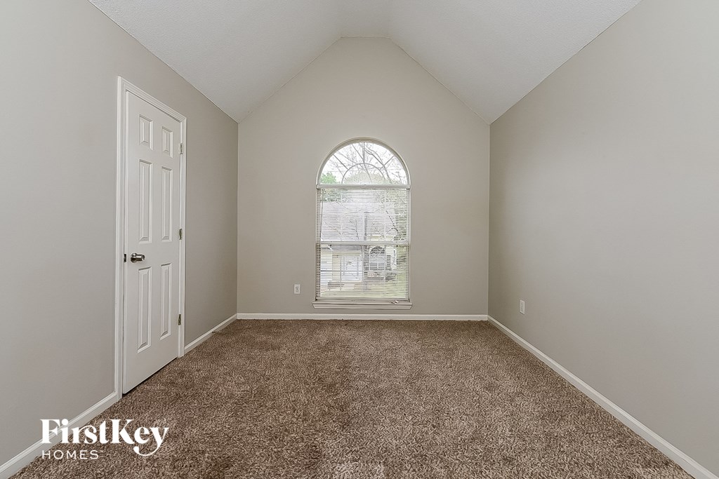 the master bedroom has carpeted floors and a large window