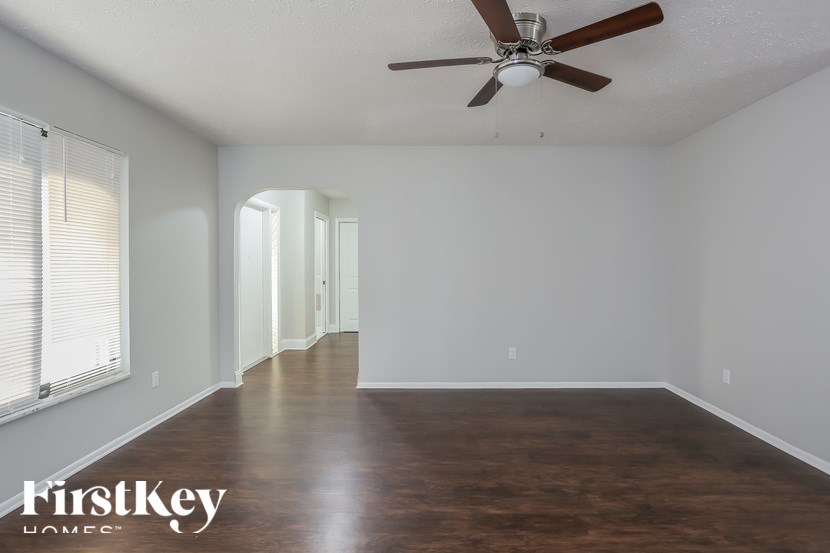 A room with a ceiling fan and wooden flooring.