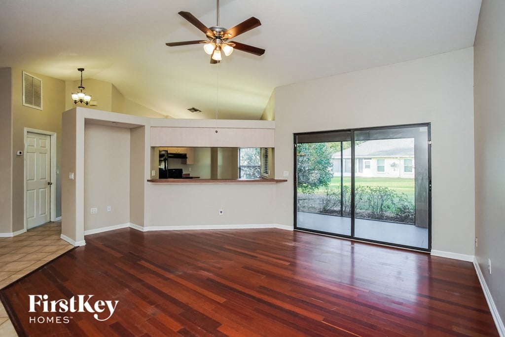 an empty living room with a sliding glass door to a patio