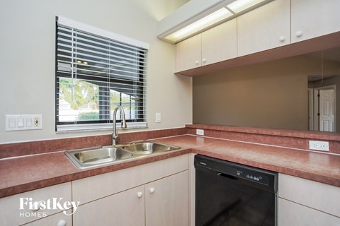 a kitchen with a sink and a dishwasher and a window