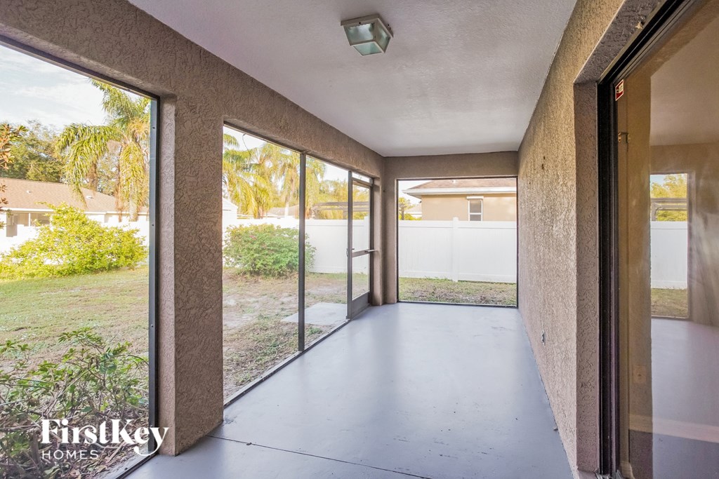 a long hallway with glass doors and a view of the yard