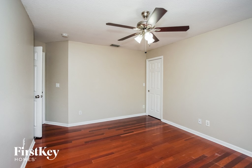 a living room with wood floors and a ceiling fan