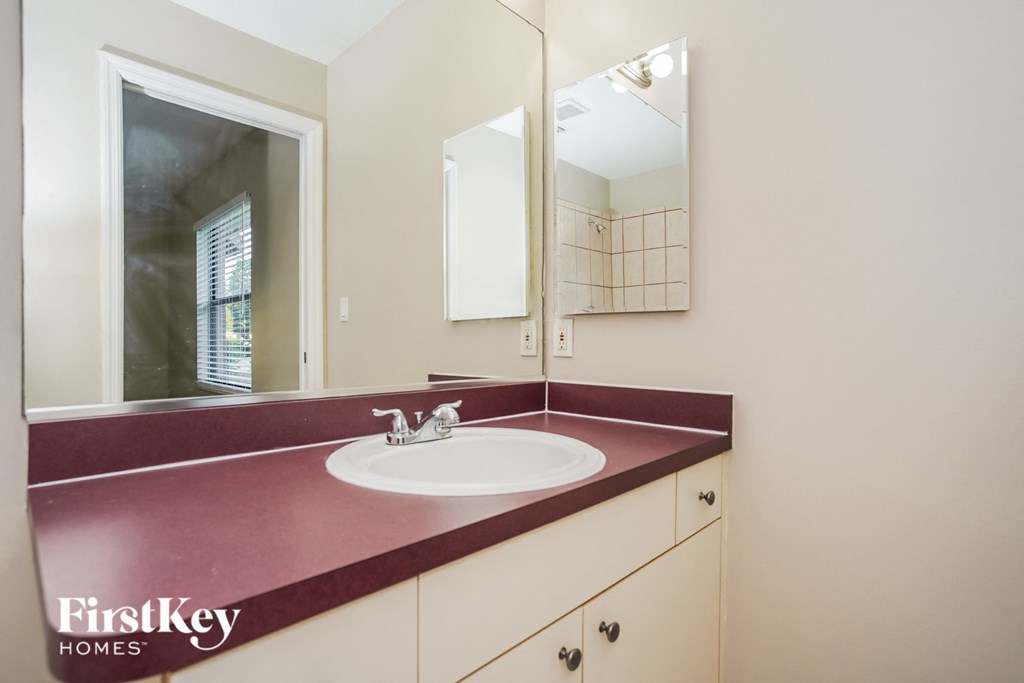 a bathroom with a sink and a mirror and a window