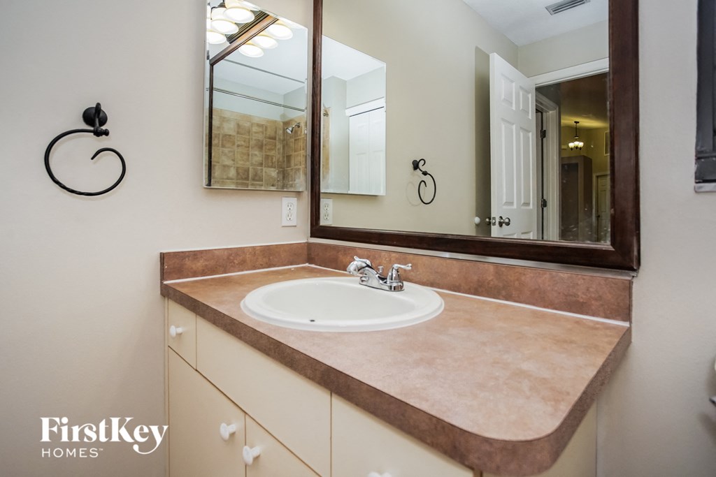 a sink in a bathroom with a mirror and a shower