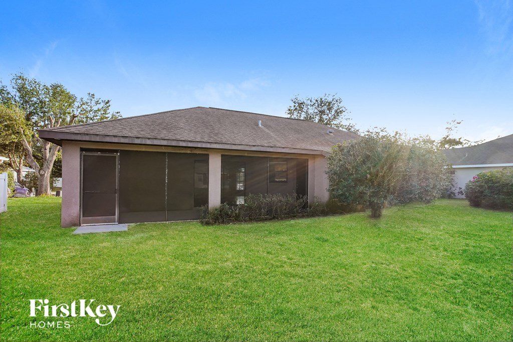 a small house with a lawn and a tree
