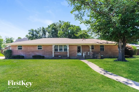 A brick house with a tree in front of it.