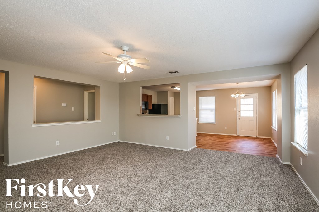 the living room of an empty house with a ceiling fan