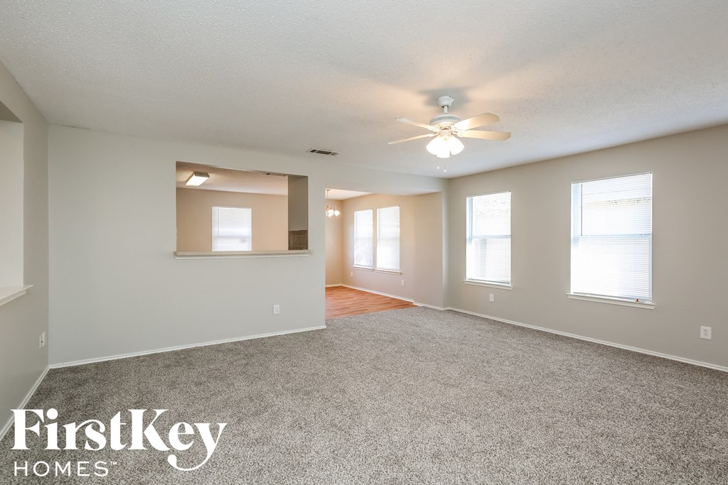 the living room of an empty house with a ceiling fan