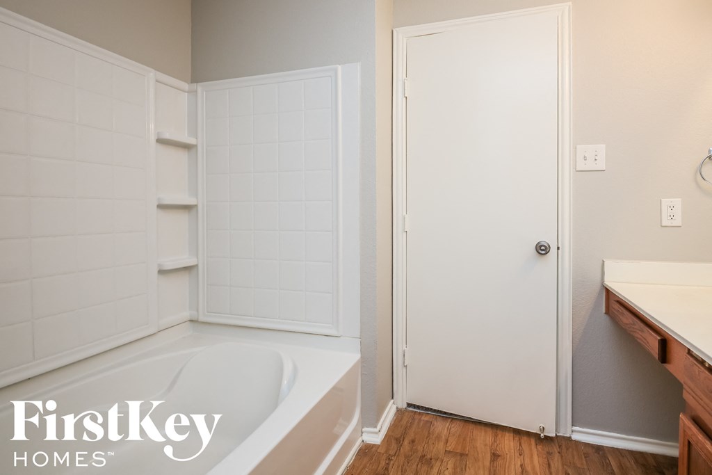 a bathroom with a tub and a shower and a closet