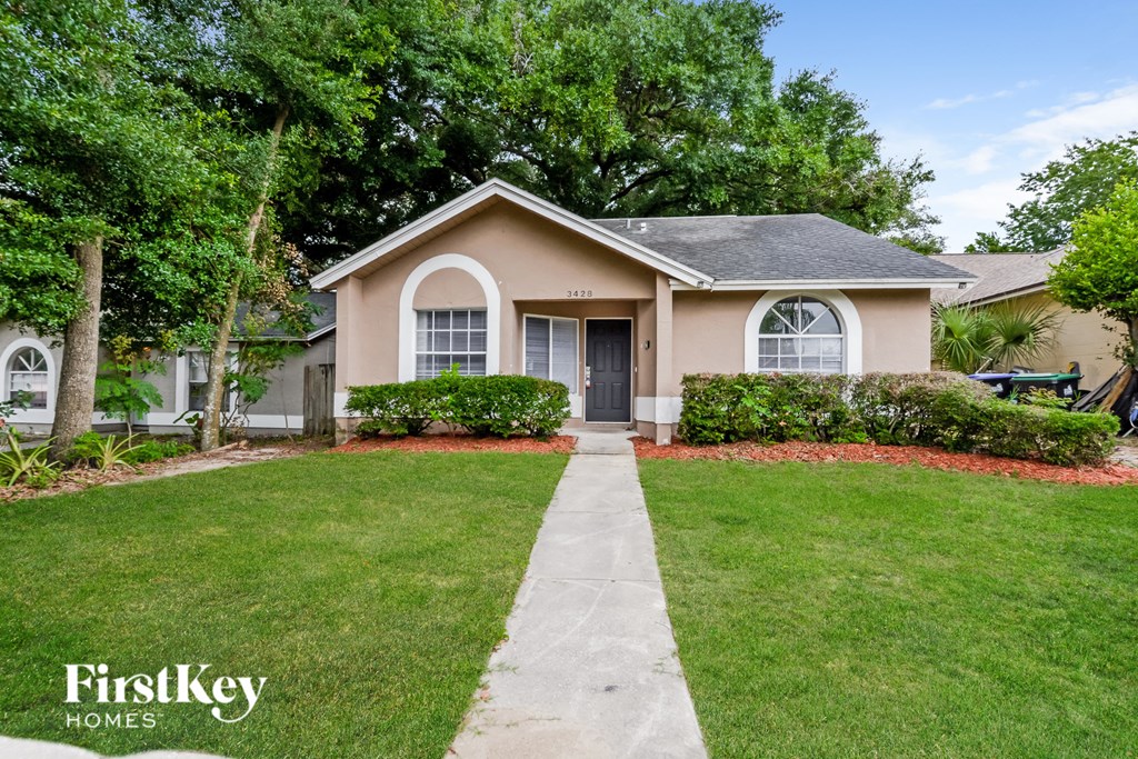 a home with a lawn and a sidewalk in front of it