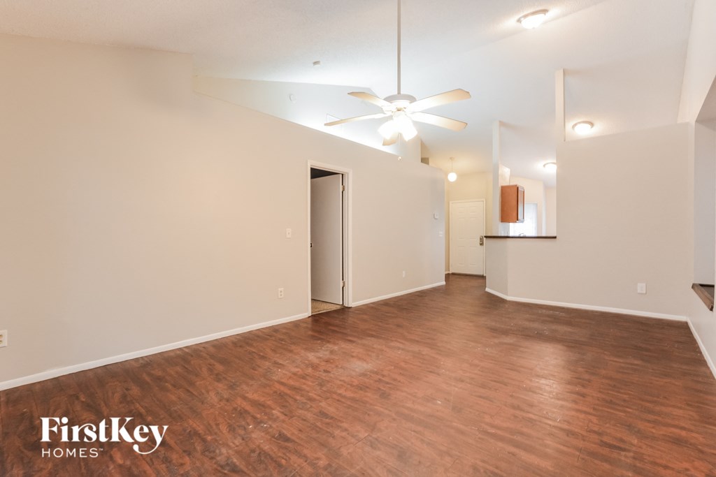 a living room with a wood floor and a ceiling fan