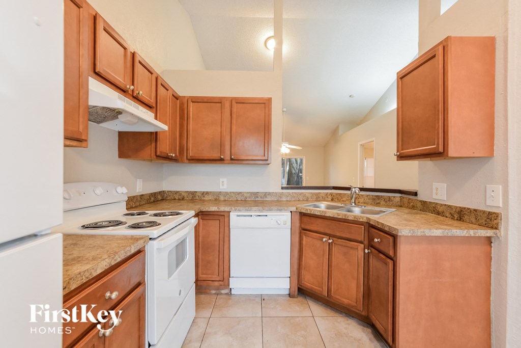 a kitchen with white appliances and wooden cabinets