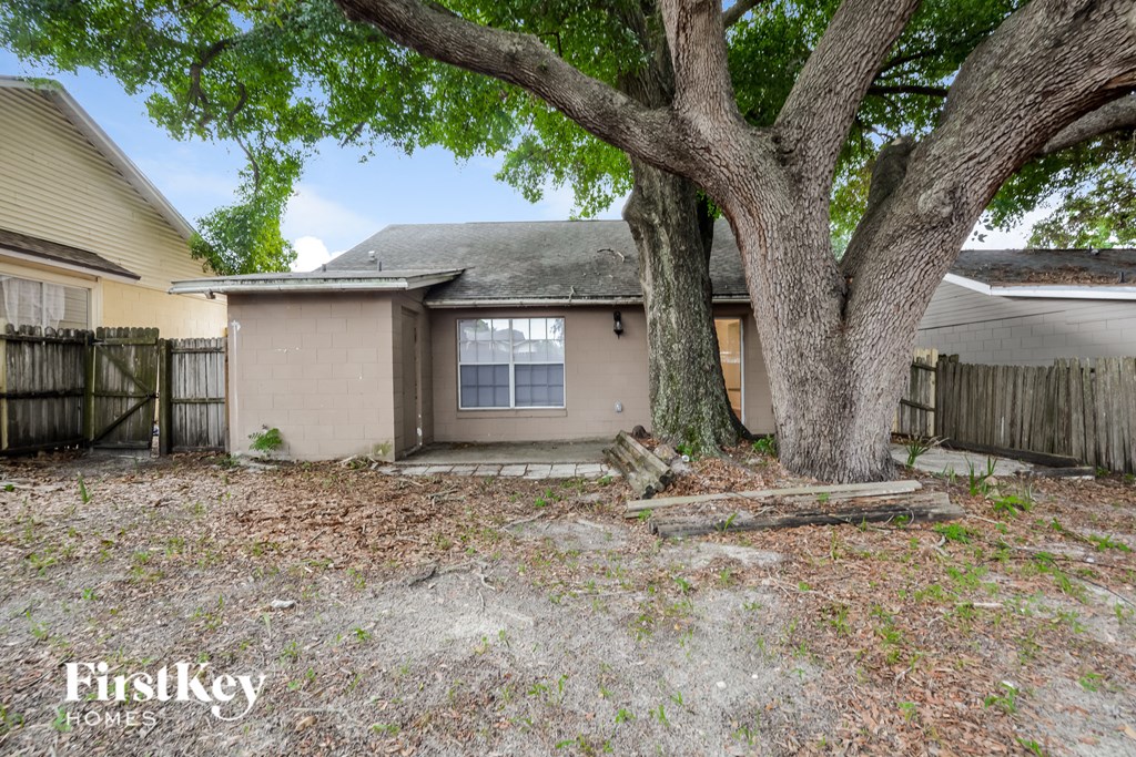 a small house with a large tree in the yard