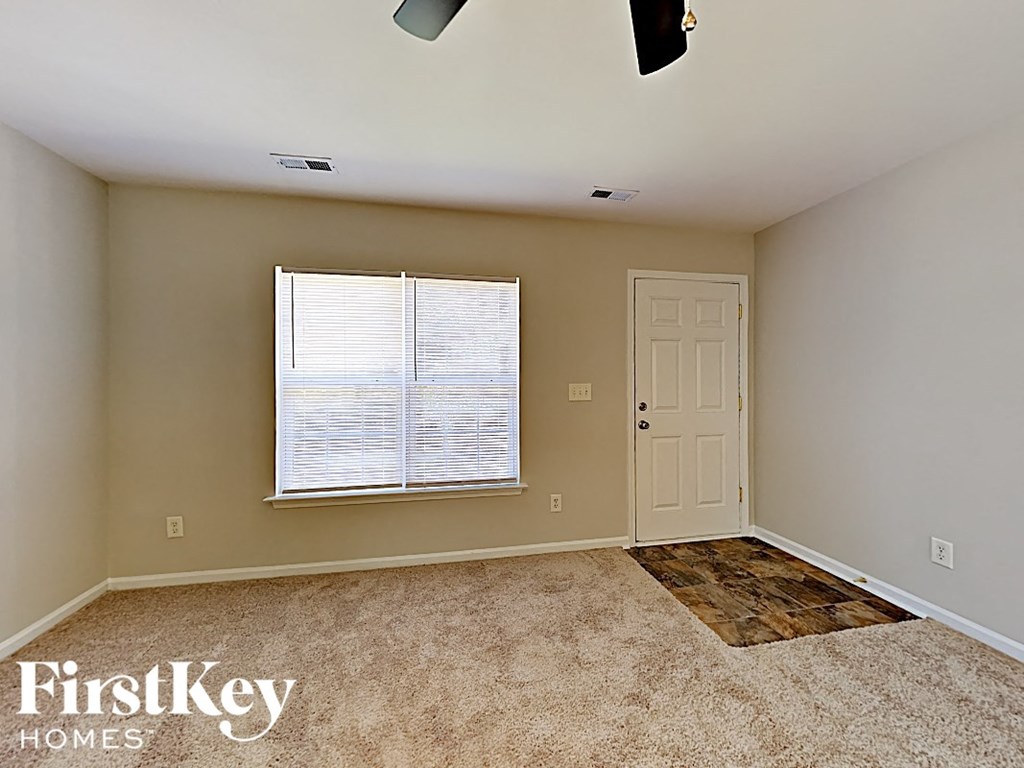 an empty room with a window and a white door