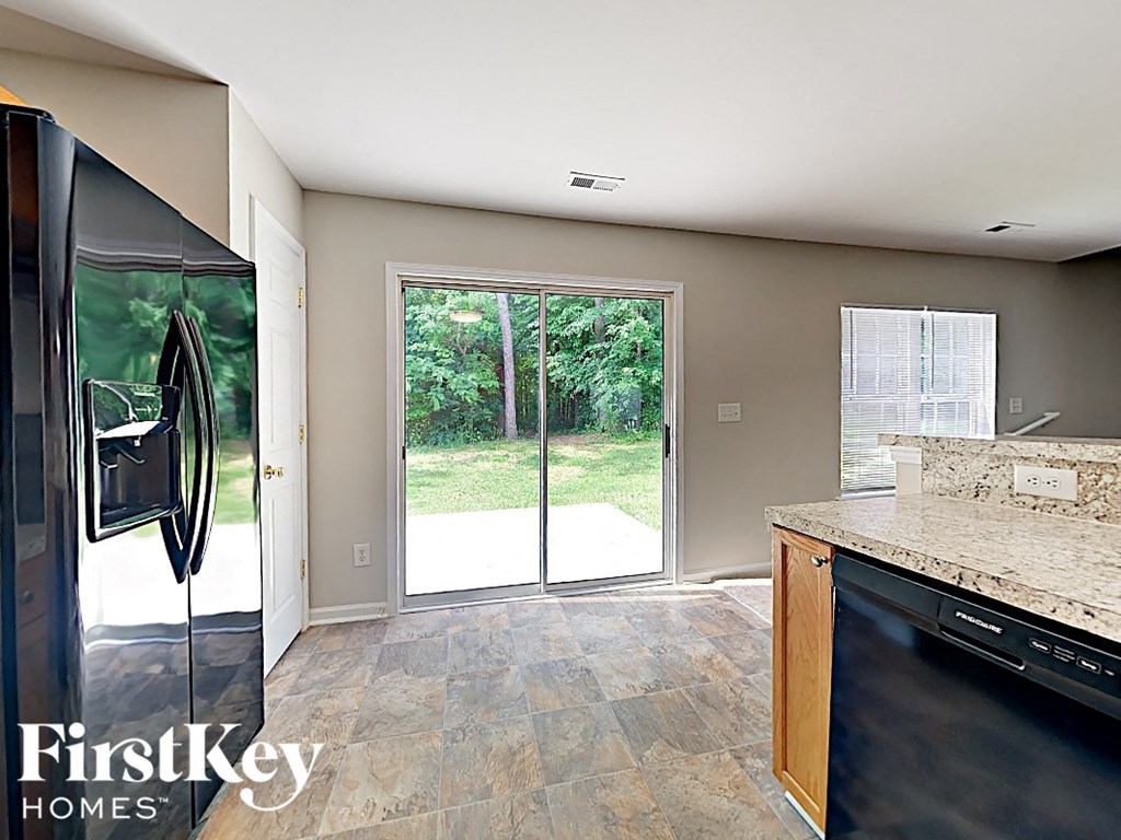 a kitchen with a stainless steel refrigerator and a door to a patio