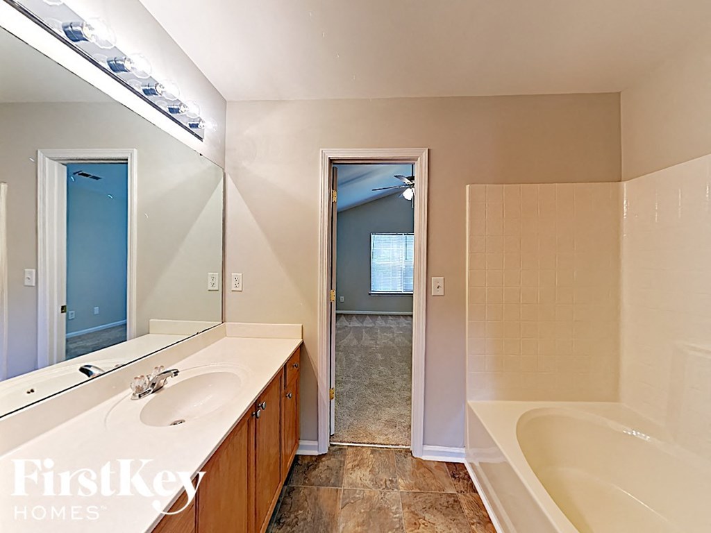 a bathroom with a tub and a sink and a mirror