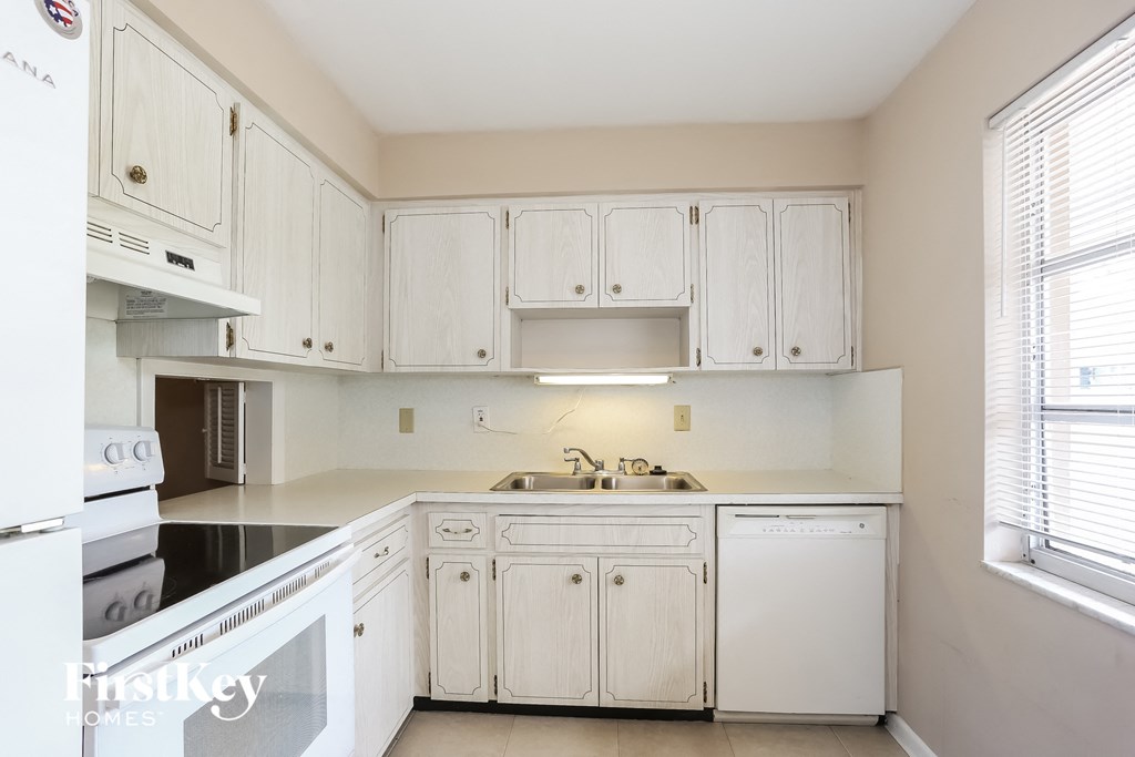 A kitchen with white appliances and cabinets.