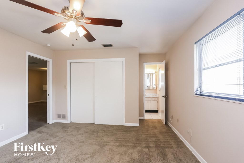 A spacious room with a ceiling fan and a window.