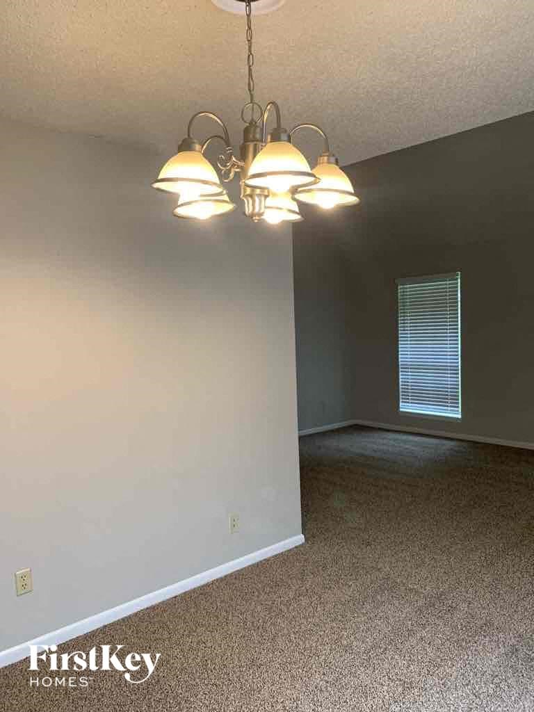 a dining room with four lights hanging from the ceiling