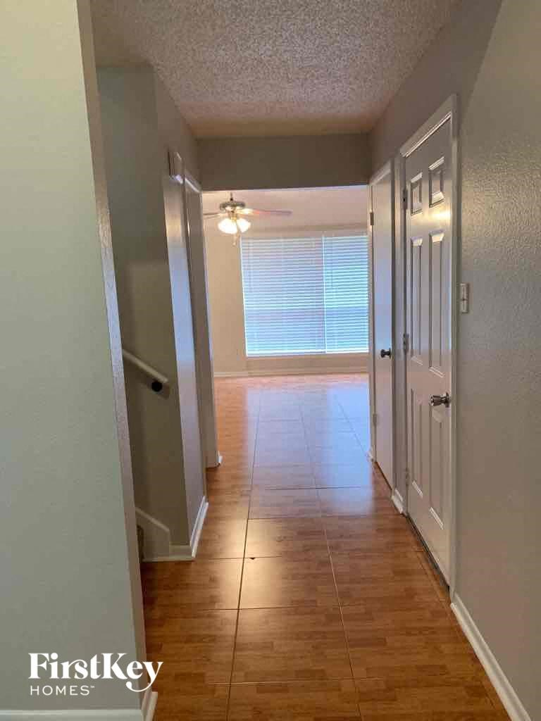 a hallway with a hard wood floor and a white door