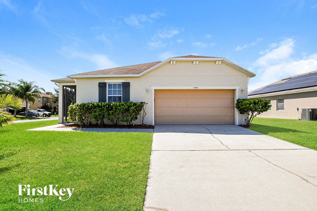 A white house with a garage door is for sale by FirstKey Homes.