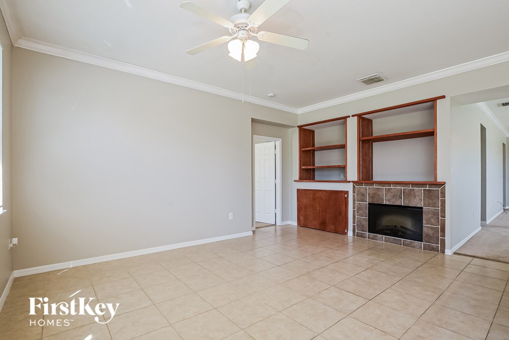 A spacious living room with a fireplace and built-in shelves.