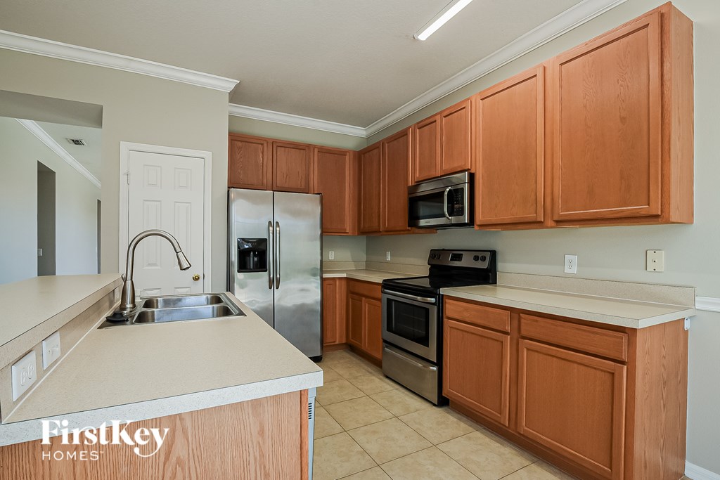 A kitchen with wooden cabinets and a stainless steel refrigerator.