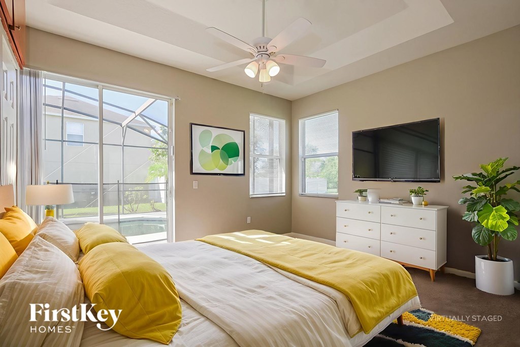 A bedroom with a bed, dresser, and television.