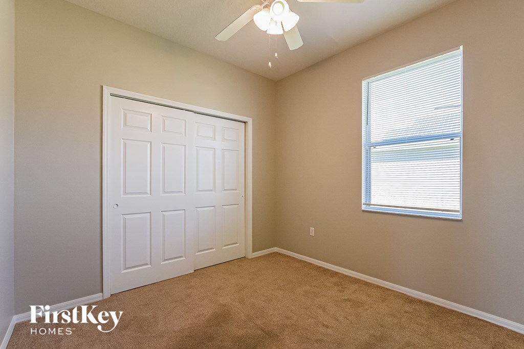 A room with a white door and a window with blinds.