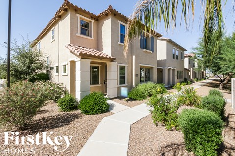 a house with a sidewalk and landscaping in front of it