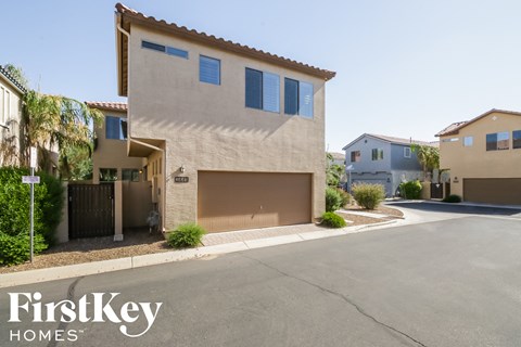 a beige house with a garage door on a street