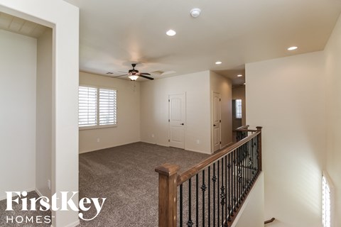 a living room with carpet and a ceiling fan