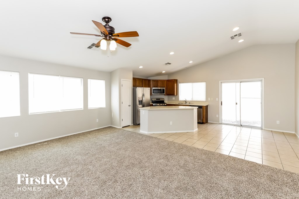 A spacious room with a ceiling fan and a kitchen area.