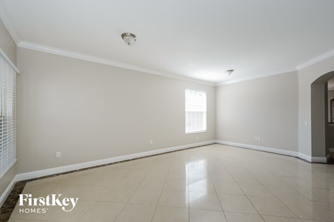 an empty living room with tiled floors and a window