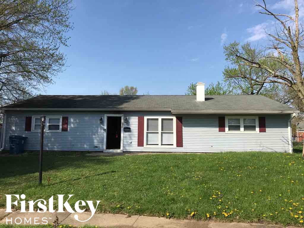 A blue house with a red door and a sign that says "FirstKey Homes".