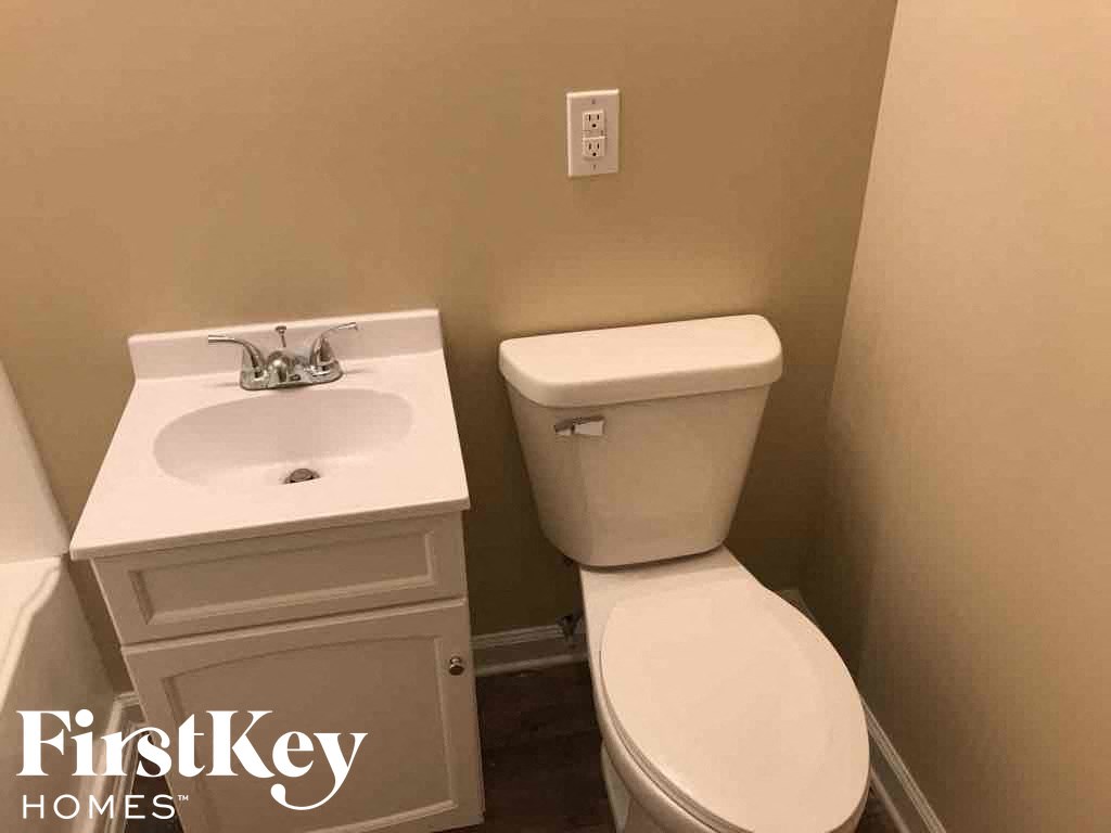 A white toilet and sink in a small bathroom.
