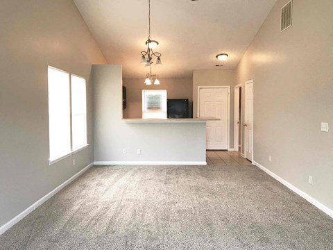 A spacious living room with a television and a carpeted floor.